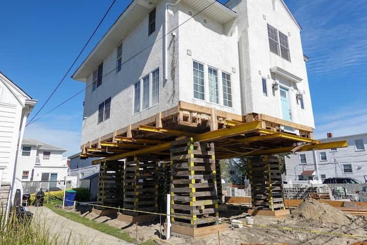 A team of professionals using specialized equipment to raise a house in Minnetonka, preparing it for elevation and renovation